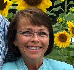 Mary Dwyer standing in front of sunflowers