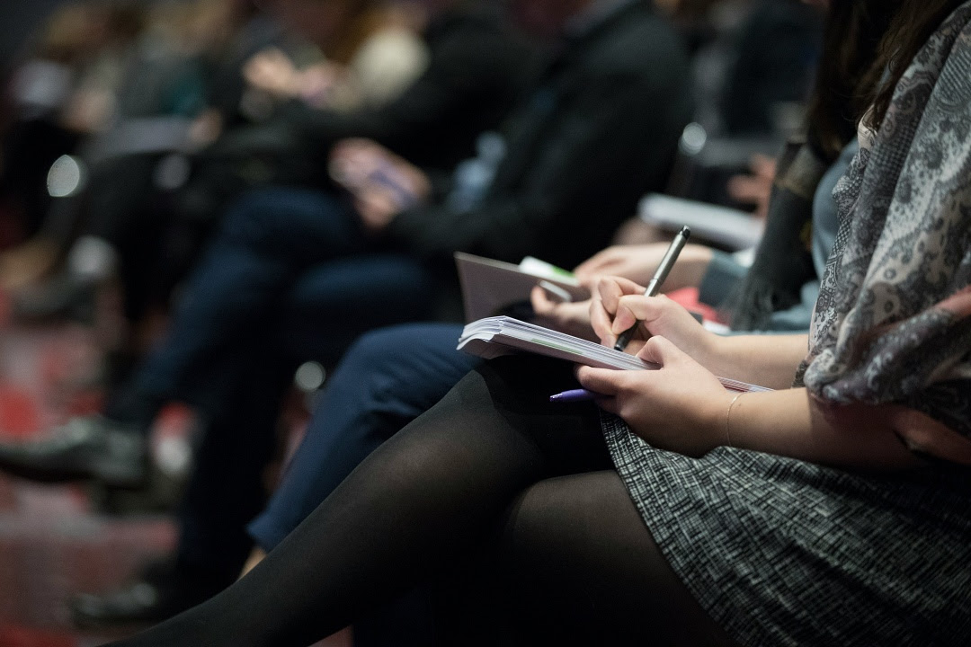 People sitting taking notes